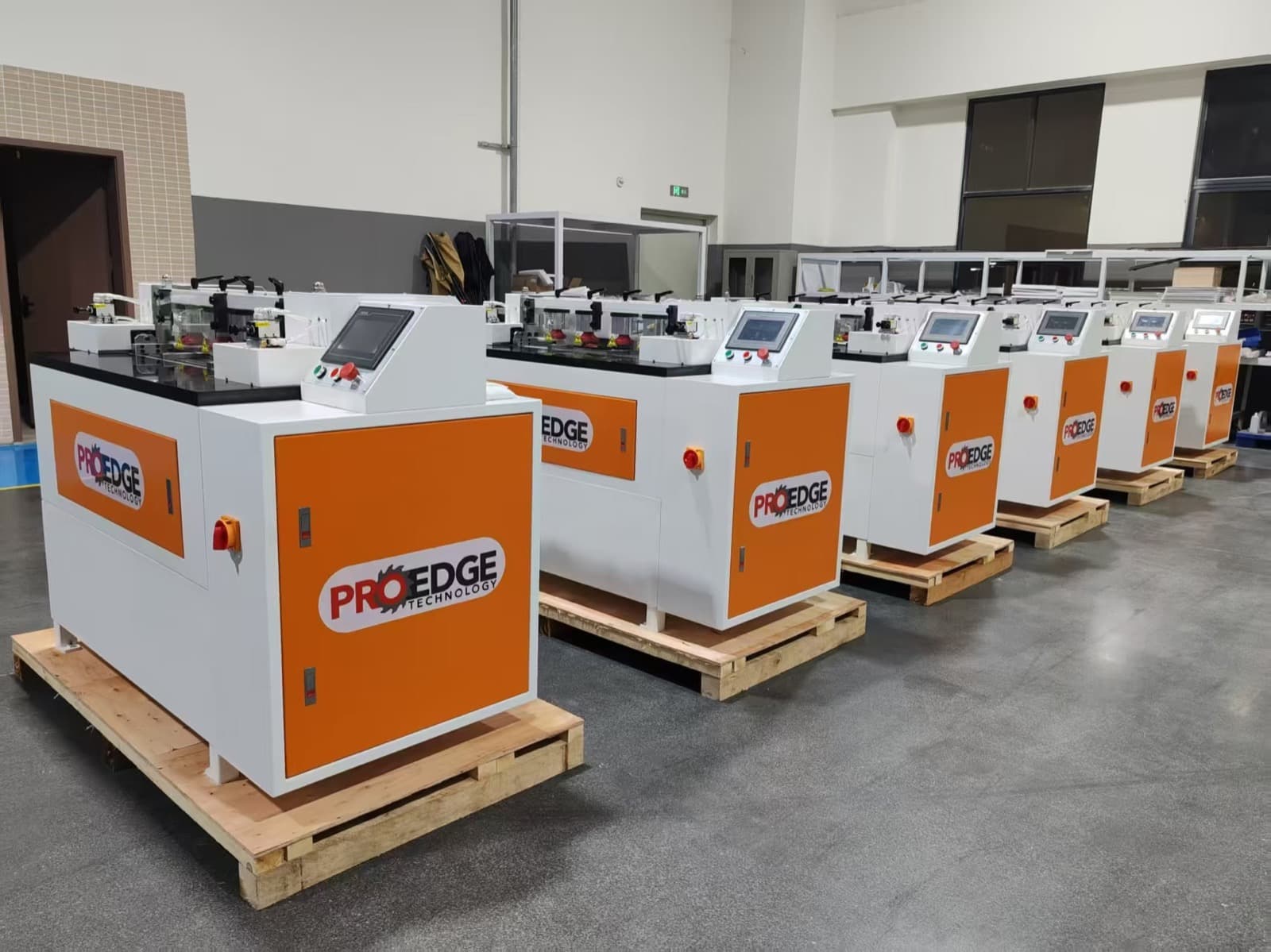 Row of newly built Pro Edge Technology CNC Dovetail machines staged on pallets in the factory, ready for shipment