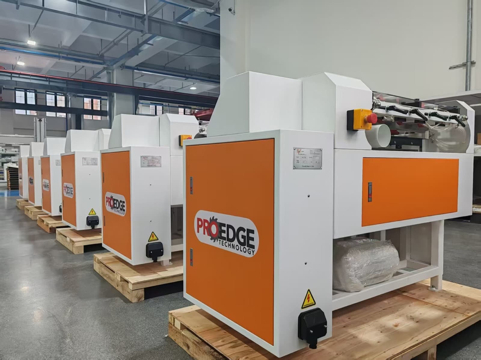 Angled rear view of a row of CNC Dovetail machines staged in the factory
