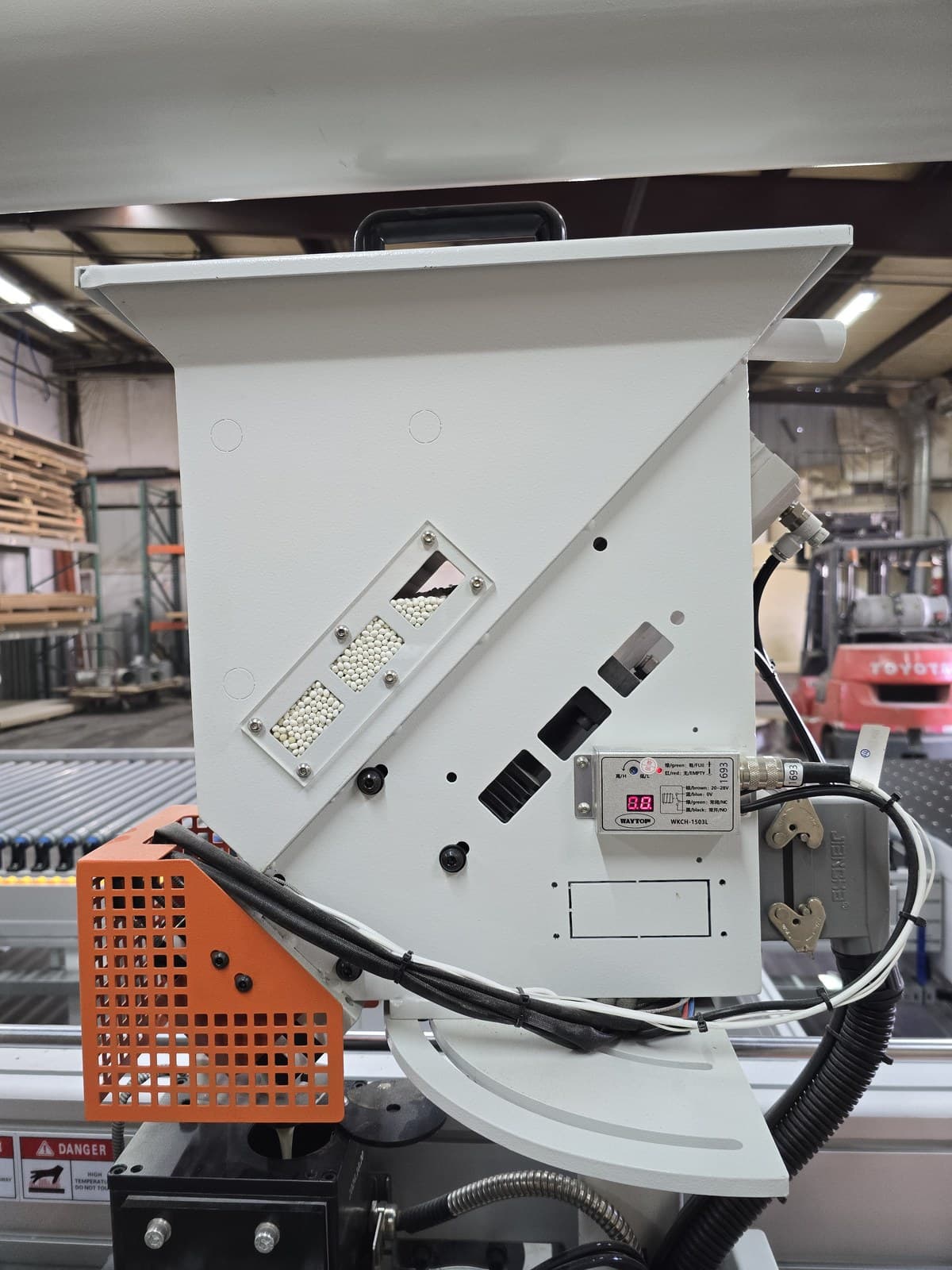 Glue pellet hopper with level windows showing hot-melt granulate