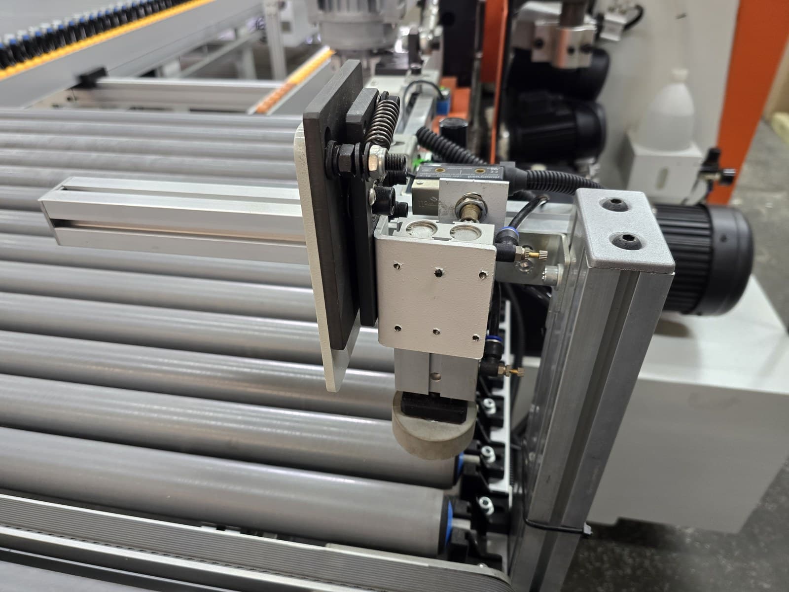 Pneumatic component mounted at the edge of the return conveyor