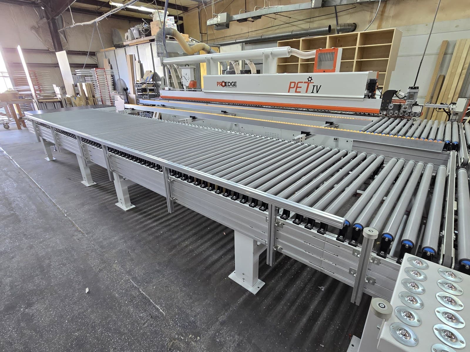 Parallel return conveyor run alongside the edgebander outfeed track