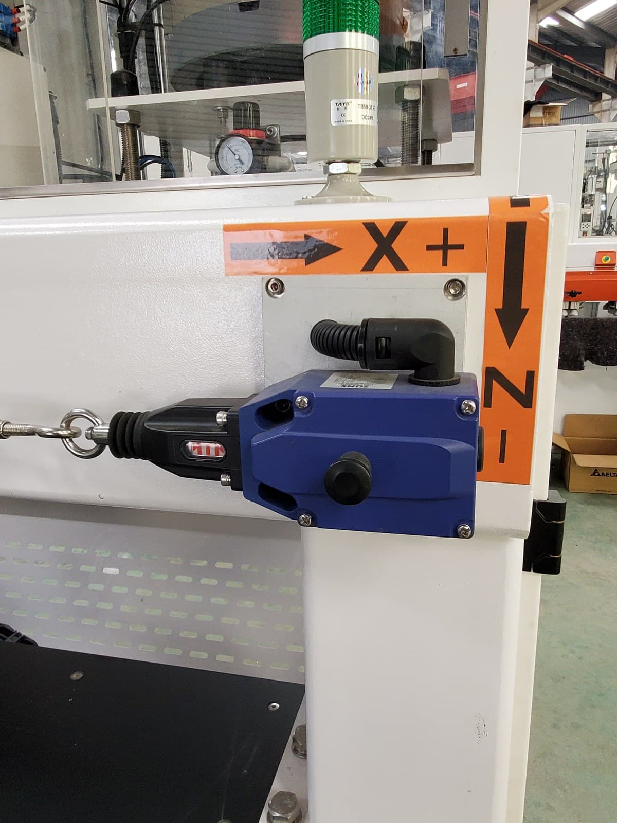 Emergency pull cord safety switch mounted on the machine frame